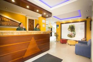 two women standing at a bar in a hotel lobby at HOTEL AMERICANA PASTO in Pasto