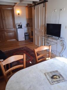 ein Wohnzimmer mit einem Tisch, 2 Stühlen und einem TV in der Unterkunft Maisonnette de Mamie in Pouilly-en-Auxois + 19 Fotos