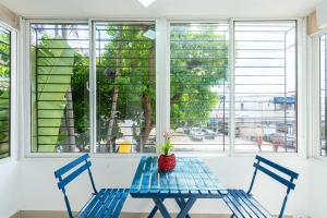 einem blauen Tisch mit zwei Stühlen vor einem Fenster in der Unterkunft Bamboo Hoouse in Santo Domingo
