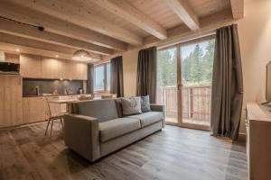 a living room with a couch and a kitchen at Chalet Alpenrose in Misurina