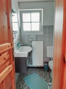 ein Bad mit einem Waschbecken, einem WC und einem Fenster in der Unterkunft Ferienwohnung Rieger in Braunlage