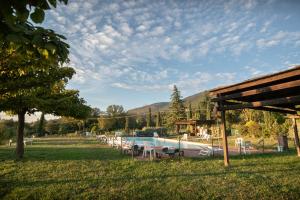 einen Pool mit Tischen und Stühlen in einem Park in der Unterkunft Agriturismo Sasso Rosso in Capodacqua