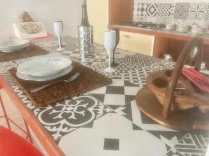 une table avec des assiettes et des verres sur un sol noir et blanc dans l'établissement Casavacanze Marie, à Pescara