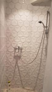 La salle de bains est pourvue d'un mur en carrelage blanc et d'une douche. dans l'établissement Bienvenue pour vous détendre, à Parbayse