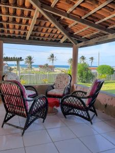 - un groupe de chaises et une table sur une terrasse couverte dans l'établissement Casa Floramar, à Parajuru