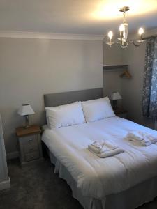um quarto com uma cama branca com duas toalhas em Pengarreg Fawr em Aberystwyth
