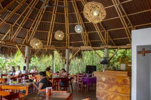 Eine Gruppe von Menschen sitzt an Tischen in einem Restaurant in der Unterkunft AXKAN PALENQUE, ALBERCAS, GASTRONOMIA MAR y TIERRA & TRAVEL AGENCY in Palenque