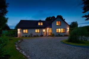 uma casa com as luzes acesas à noite em By the Brae em Inverness