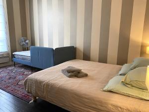 a bedroom with a bed and a chair and a fan at Outstanding 2 bedrooms with a terrific Eiffel Tower view in Paris