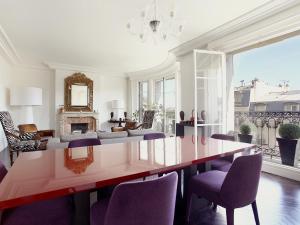 ein Esszimmer mit einem großen Tisch und lila Stühlen in der Unterkunft Outstanding 2 bedrooms with a terrific Eiffel Tower view in Paris