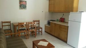 a kitchen with a table and a white refrigerator at Villa Sophia in Ofrínion