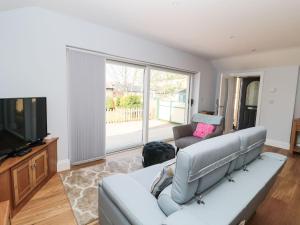 a living room with a couch and a tv at 3 The Paddock in Chathill