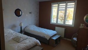 sypialnia z 2 łóżkami, lustrem i oknem w obiekcie chez David w mieście Bressuire