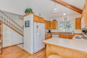 a kitchen with a white refrigerator and wooden cabinets at Eagle Crest Resort on Golf Course with Hot Tub in Redmond