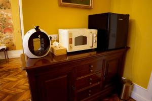 a microwave sitting on top of a dresser with a mirror at Filip Apartment Oradea in Oradea