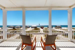 two chairs on a porch overlooking the beach at All Decked Out in Fort Morgan