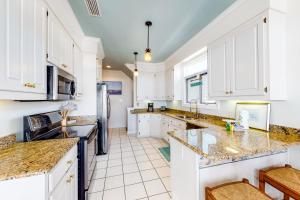 a kitchen with white cabinets and marble counter tops at All Decked Out in Fort Morgan