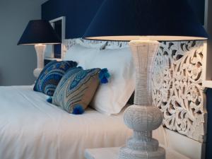 a blue bedroom with a white bed with two lamps at Château La Gravière in Vertheuil-en-Médoc