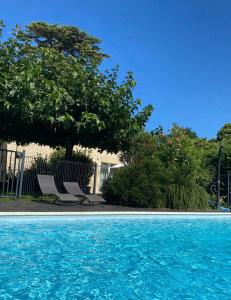 a pair of chairs sitting next to a swimming pool at Château La Gravière in Vertheuil-en-Médoc