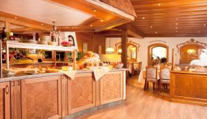 a large kitchen with wooden walls and wooden floors at Landhotel Strasserwirt in Sankt Ulrich am Pillersee