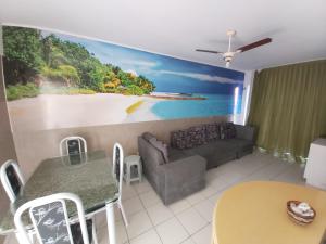 a living room with a couch and a painting on the wall at Village Hospedagens in Natal