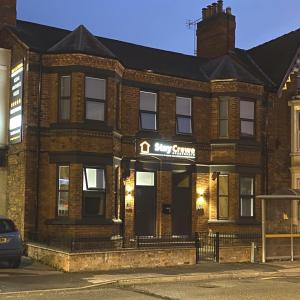 a brick building with a sign on it at StayCrewe Apartments in Crewe