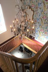 a chandelier hanging over a staircase with a chair at Eagle House - award winning luxury B&B and Apartment in Eccleshall