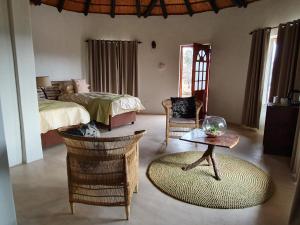 1 dormitorio con 1 cama, mesa y sillas en Somkhanda Game Reserve, en Pongola