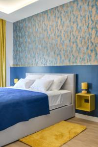 a bedroom with a bed with a blue wall at Royal residence Zagreb in Zagreb