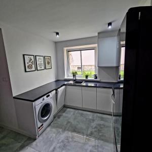 a kitchen with a washing machine and a sink at APARTAMENT PRZY RONDZIE in Kłodzko