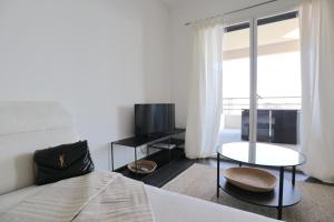 1 dormitorio con 1 cama, TV y mesa en Luxurious Apartments Monaco&SeaView, InfinityPool&Parking, en Beausoleil