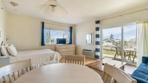 a bedroom with a bed and a table and a room with a window at Windward Shores in Amagansett +168 photos