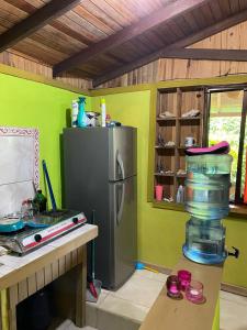 
a kitchen with a refrigerator, stove, and a microwave at Bungalows Kire in Puerto Viejo
