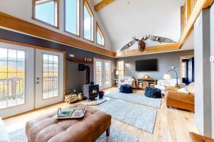 a living room with a vaulted ceiling with windows at The Maine Glades in Newry