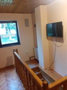 a room with a television on the wall and a stair case at Kuca za odmor Zlatibor in Zlatibor