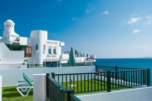 een wit huis met een balkon met uitzicht op de oceaan bij Blancazul Los Clicos in Playa Blanca