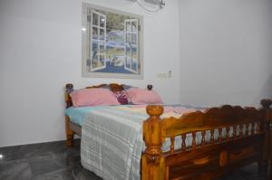 本地治里的住宿－Vasantham Villas，卧室配有一张床,墙上挂着一幅画
