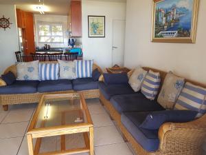 ein Wohnzimmer mit einem blauen Sofa und einem Tisch in der Unterkunft 3 Marina Palms, Woodgrange-on-sea in Hibberdene