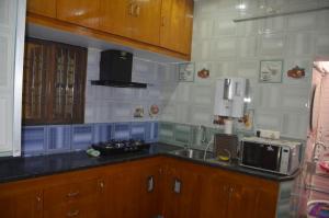 a kitchen with a sink and a microwave at Vasantham Villas in Puducherry +48 photos