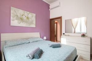 sypialnia z łóżkiem i fioletową ścianą w obiekcie Casa Paola - Downtown Cernobbio w mieście Cernobbio