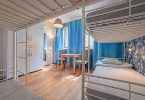 a bedroom with two bunk beds and a table at Tatamka Hostel in Warsaw