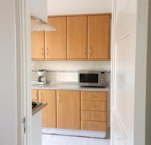 a kitchen with wooden cabinets and a microwave at AL CASA GRANDE in Olhão +11 photos