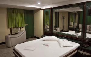 Hotel Xanadu - Adults Only في ريو دي جانيرو: غرفة الفندق بسرير ومرآة