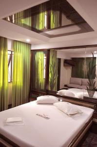 a bedroom with two beds with green curtains at Hotel Xanadu - Adults Only in Rio de Janeiro