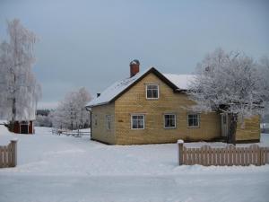 una casa de ladrillo en la nieve con una valla en Flahult Holiday Home, en Hok