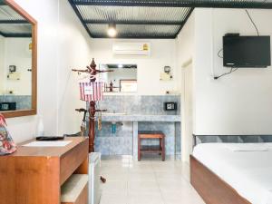 a bedroom with a fireplace and a bed and a television at Samet Bellhouse in Ko Samed