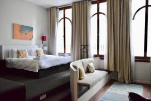 um quarto com uma cama, um sofá e janelas em 1 Bedroom Apartment with Roof Top Views em Cidade do Cabo