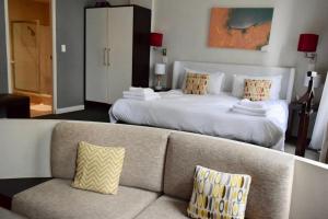 uma sala de estar com uma cama grande e um sofá em 1 Bedroom Apartment with Roof Top Views em Cidade do Cabo