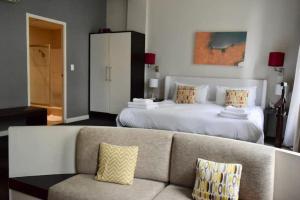 uma sala de estar com um sofá e uma cama em 1 Bedroom Apartment with Roof Top Views na Cidade do Cabo