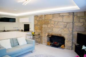 ein Wohnzimmer mit einem Sofa und einem Steinkamin in der Unterkunft Bright 1 Bedroom City Centre Home with Historic Twist in Edinburgh